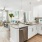 Model kitchen and living room at The Grove at Coastal Grand apartments in Myrtle Beach, SC, featuring wood grain flooring.