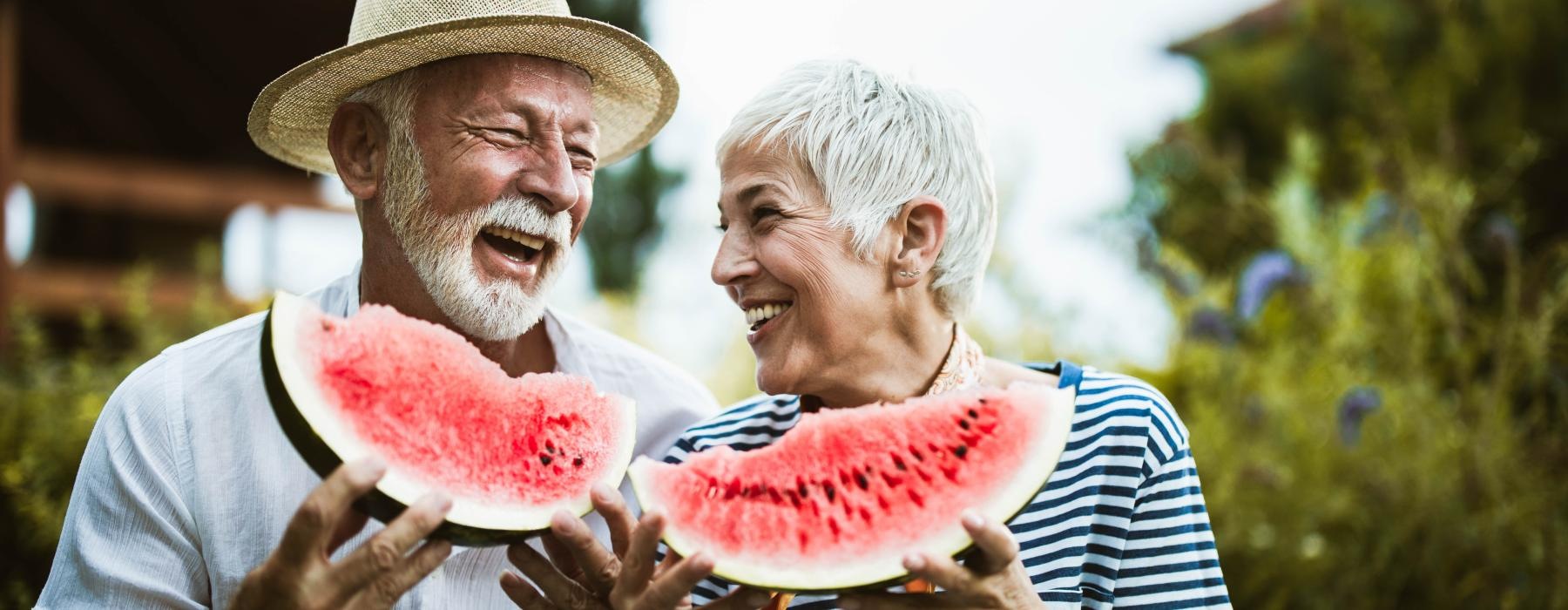 a man and a woman eating watermelon